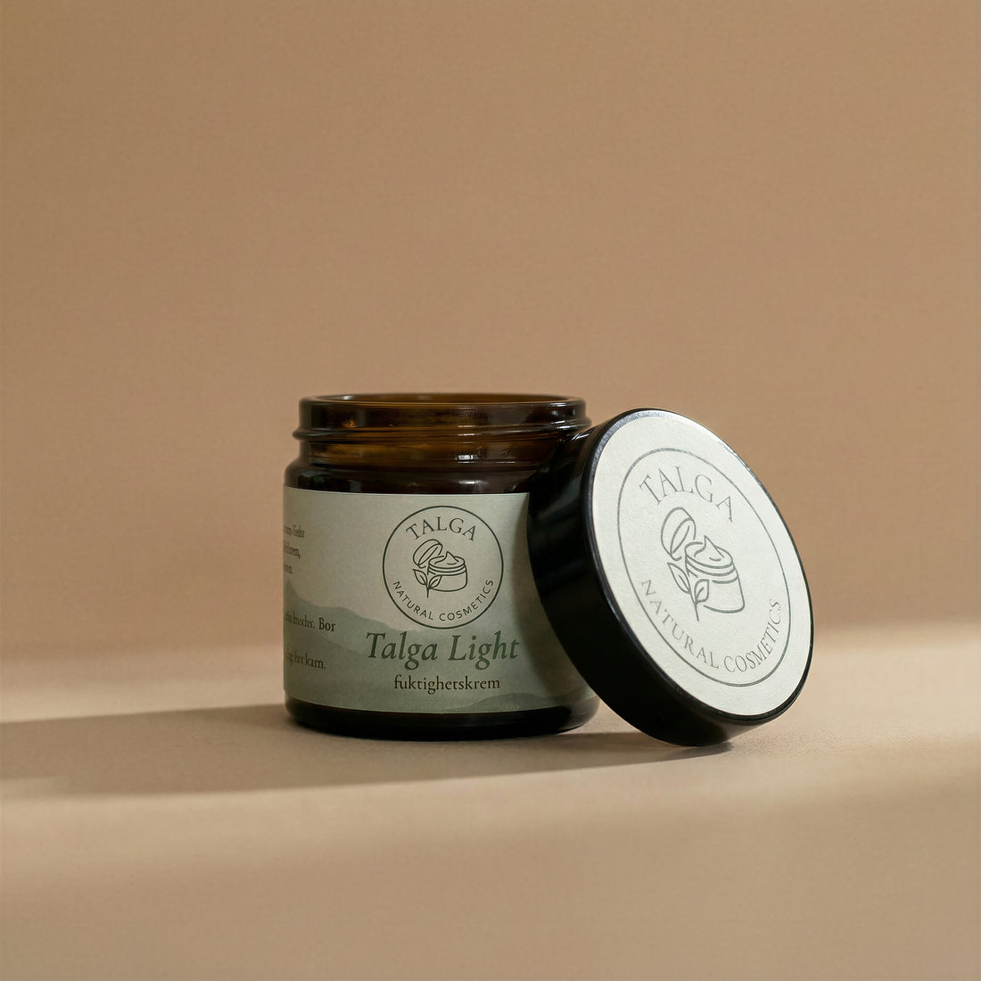 Talga Light moisturizing cream jar with the lid resting beside it on a beige background.