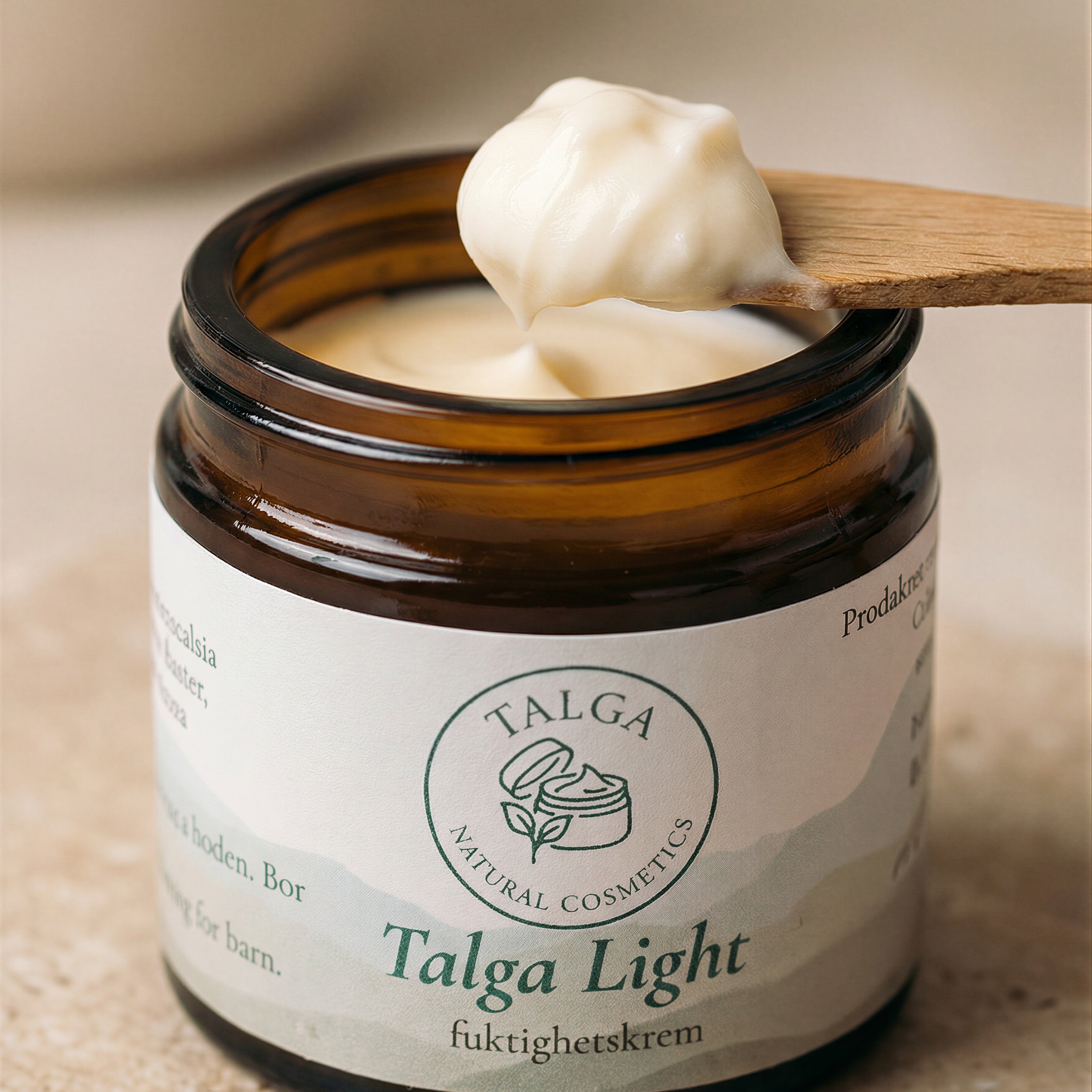 Closeup of Talga Light moisturizing cream jar with a spatula scooping out some of the cream.