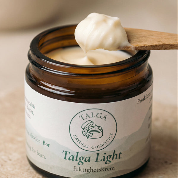 Closeup of Talga Light moisturizing cream jar with a spatula scooping out some of the cream.