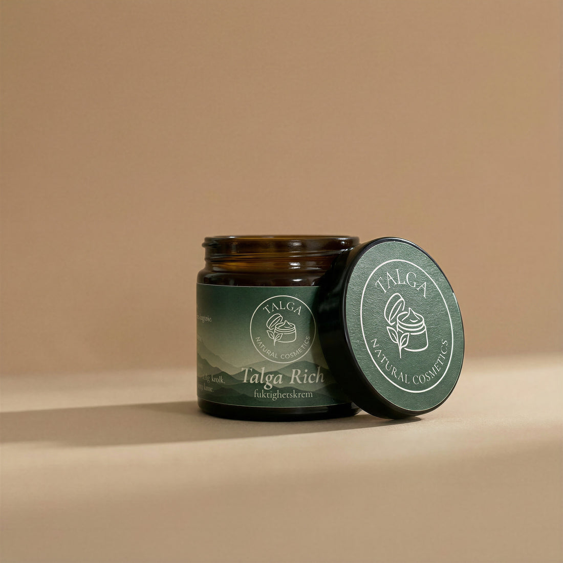 Talga Rich moisturizing cream jar with the lid resting beside it on a beige background.